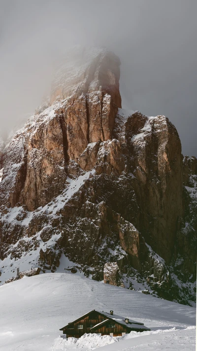 Paisaje montañoso nevado con una cabaña rústica