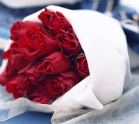 Élégant bouquet de roses rouges enveloppé dans du papier blanc.