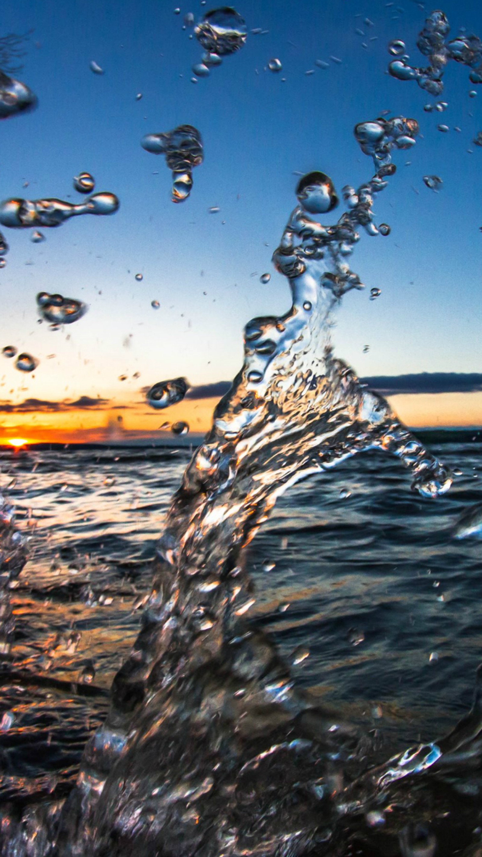 Une vague qui se brise sur la plage au coucher du soleil avec un ciel bleu (eau, profite, frais)