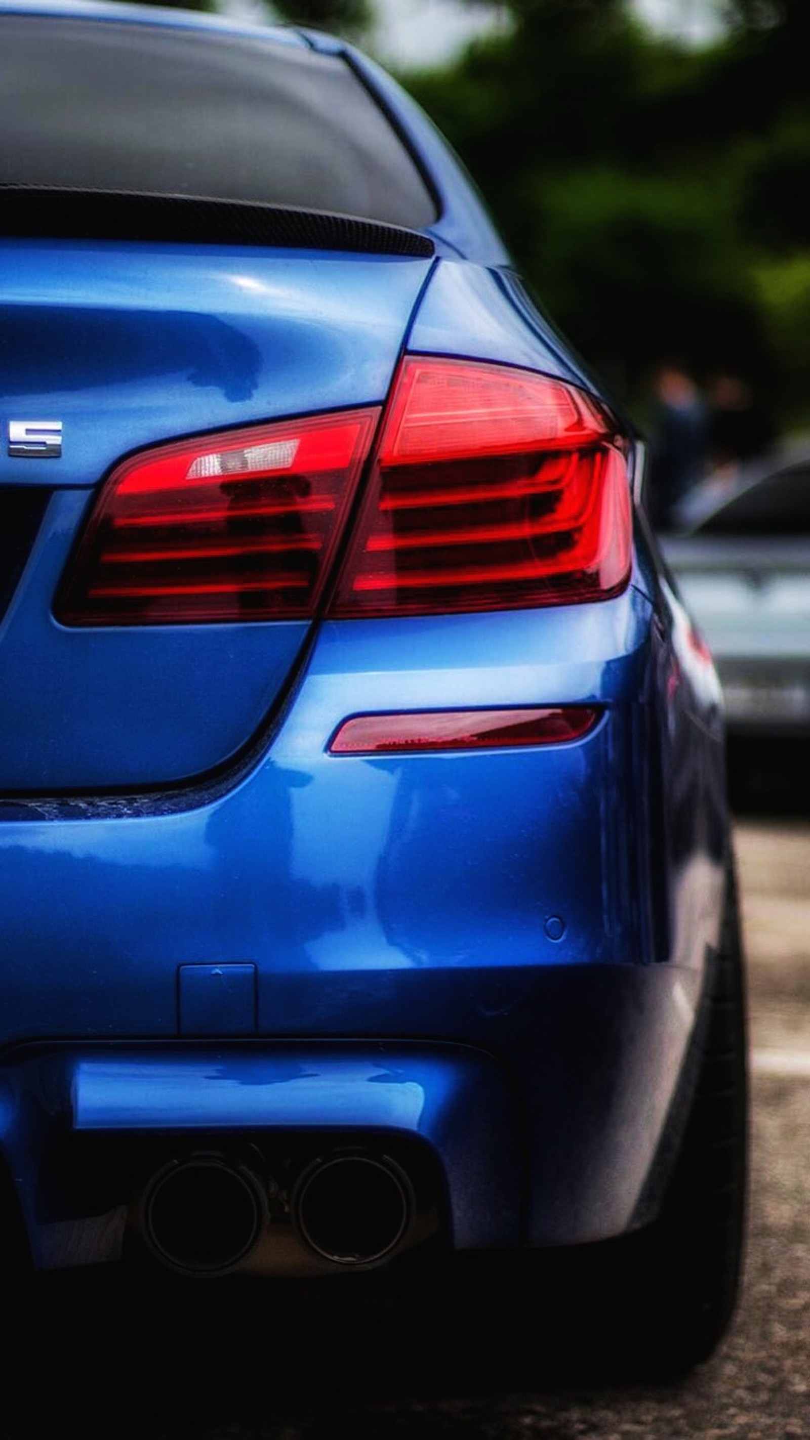 There is a blue car parked in a parking lot with other cars (auto, blue, bmw, car, f10)