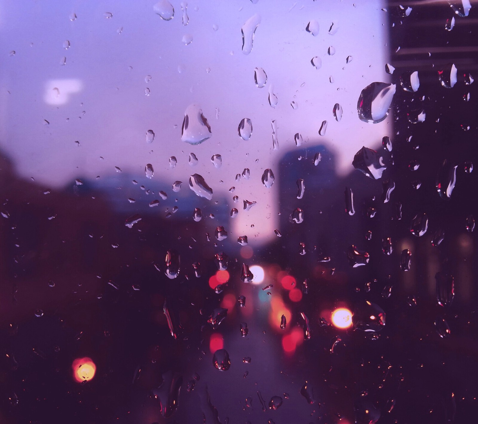 Arafed view of a city street through a rain covered window (blurry, moist, moisture, rain, rainy)