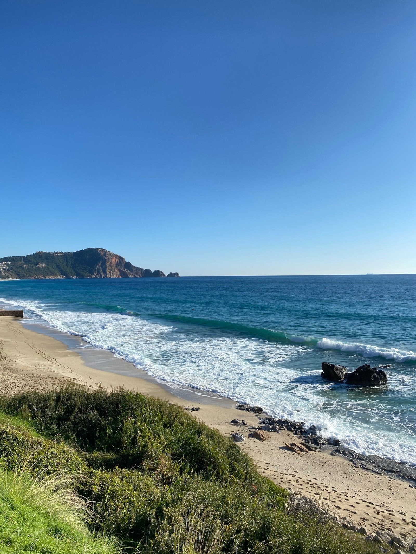 Uma praia com um banco e vista para o oceano. (praia cleópatra, água, nuvem, ecorregião, paisagem natural)