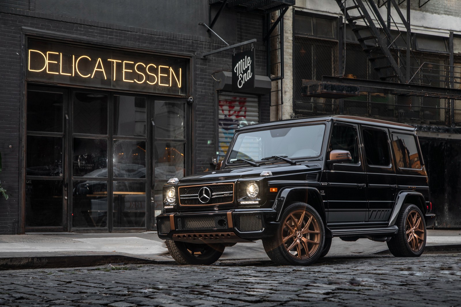 Um close de um mercedes g-class preto estacionado em uma rua da cidade (carro, pneu automotivo, pneu, roda, mercedes benz g class)