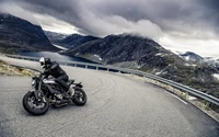 Conductor navegando por una carretera montañosa curva en una motocicleta Husqvarna