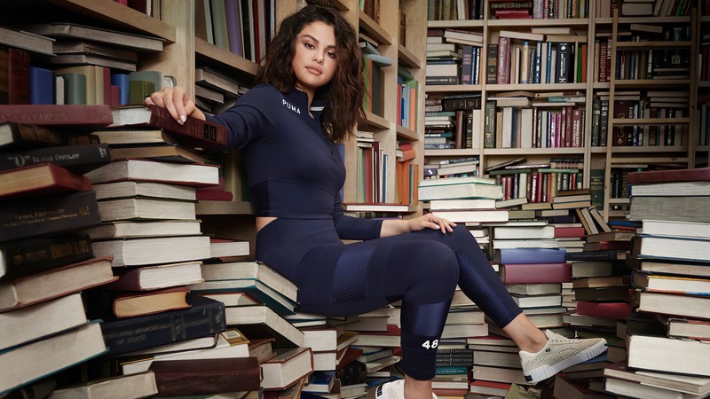 Женщина сидит на куче книг в библиотеке (селена гомес, selena gomez, певец, знаменитость, женщины)