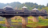 Traditional Bridge Showcasing Chinese Architecture Amidst Scenic Village Landscape