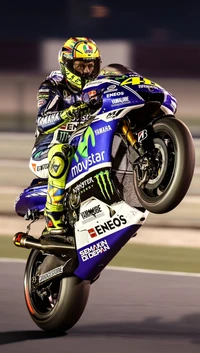 Валентино Росси выполняет вилли на своем мотоцикле Yamaha MotoGP