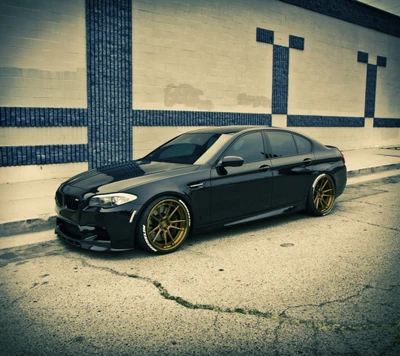 BMW M5 F10 sedan preto modificado com rodas douradas personalizadas