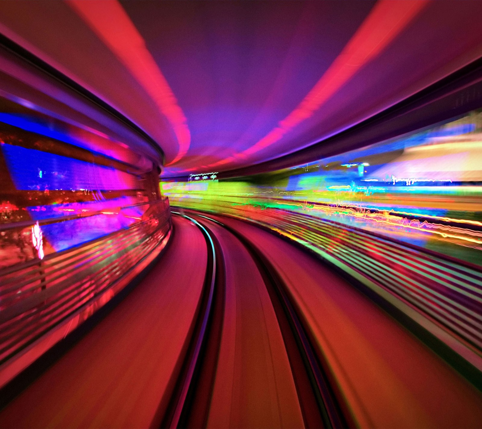 Una vista aérea de un tren que se mueve a través de un túnel con luces coloridas (colorido, camino)