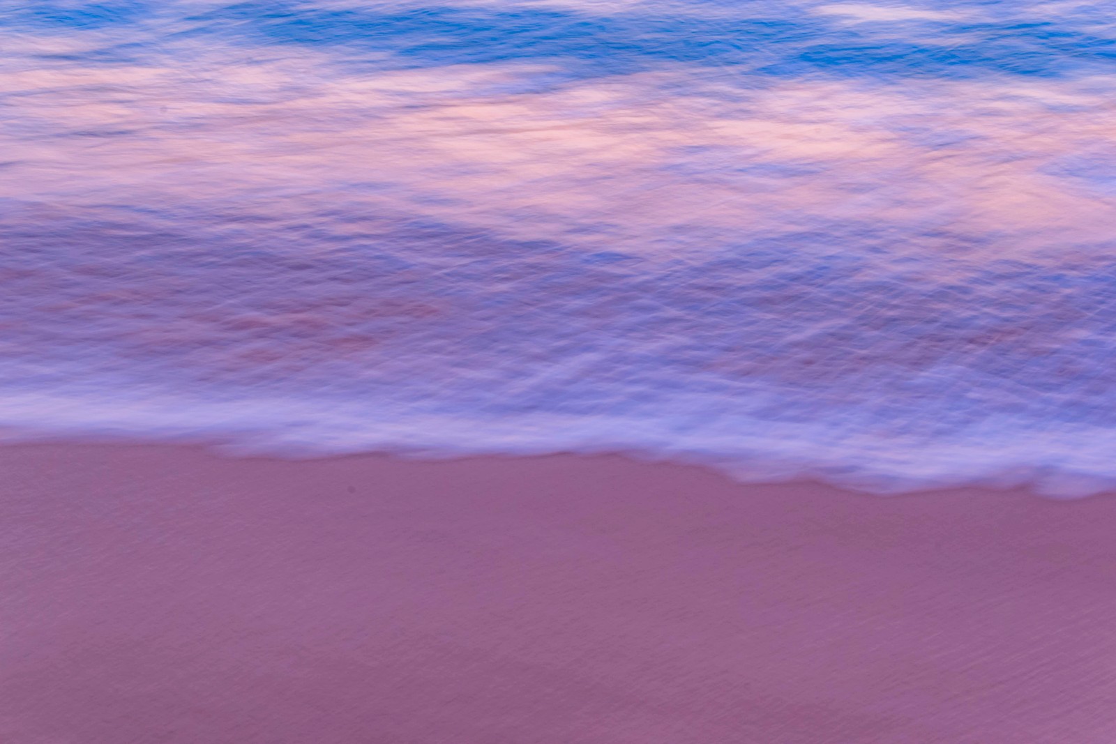 Girafe marchant sur la plage avec une planche de surf dans l'eau (bleu, violet, nuage, rose, mer)