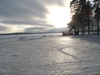 Morning Sunlight Breaking Through Clouds Over a Snow-Covered Landscape