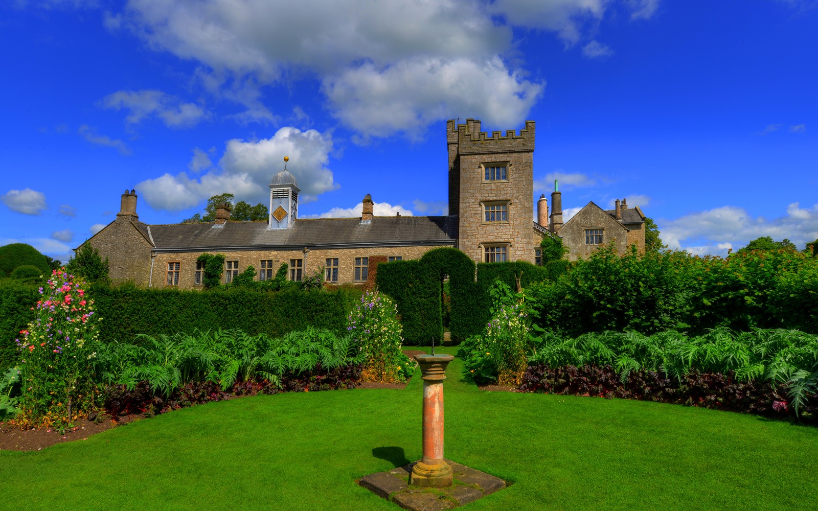 Arafed view of a large building with a clock tower in the middle of a garden (park, fountain, green, property, estate)