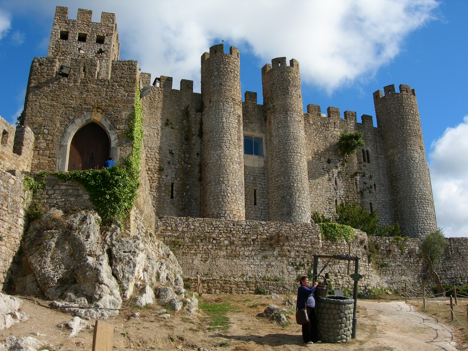 There is a man standing in front of a castle with a bucket (porto, castle, travel, fortification, ruins)