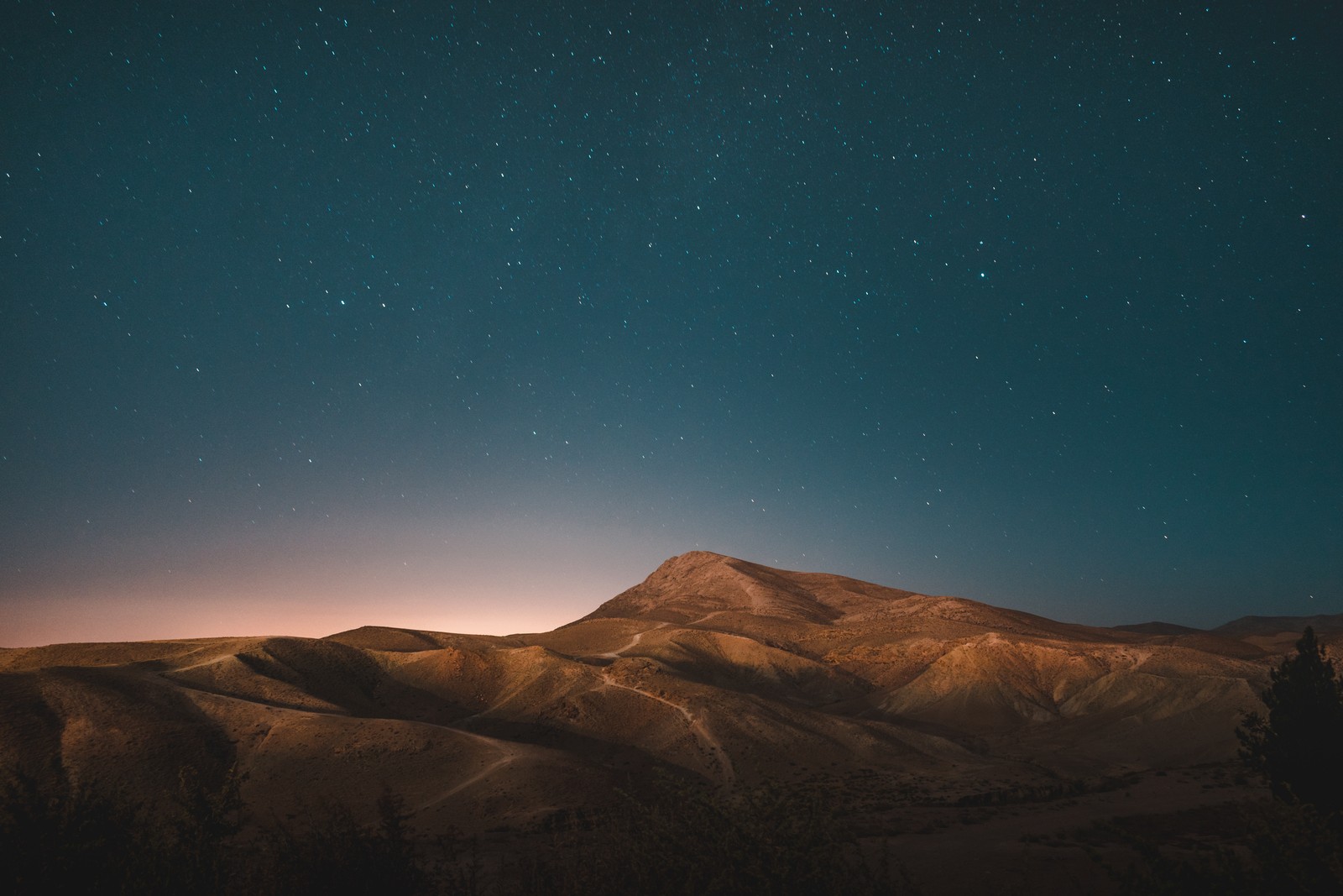 Uma vista de uma montanha com um céu cheio de estrelas (céu noturno, estrela, noite, atmosfera, horizonte)