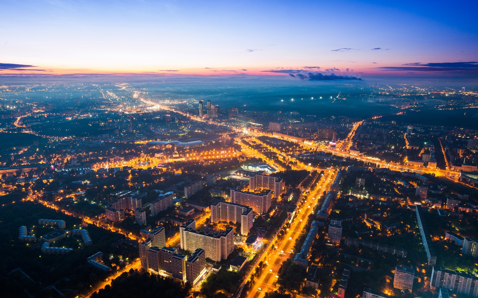 A view of a city at night from a high up (urban area, cityscape, city, horizon, broadcasting)