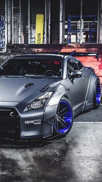 Nissan GTR modificado con acabado mate elegante y llamativas llantas azules, que muestra ajuste de rendimiento y estilo automotriz japonés.