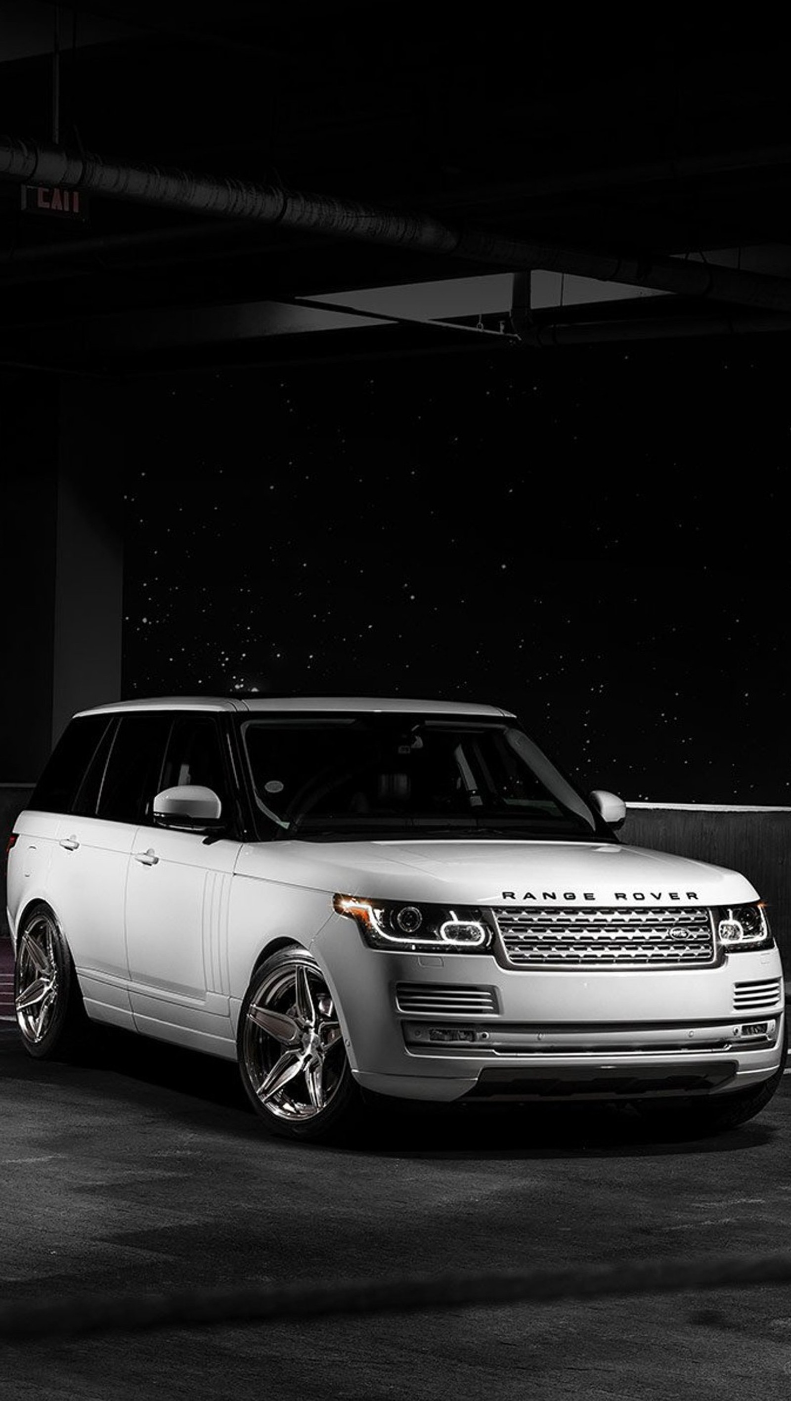 Arafed range rover parked in a parking garage with a black background (car, range rover, white)