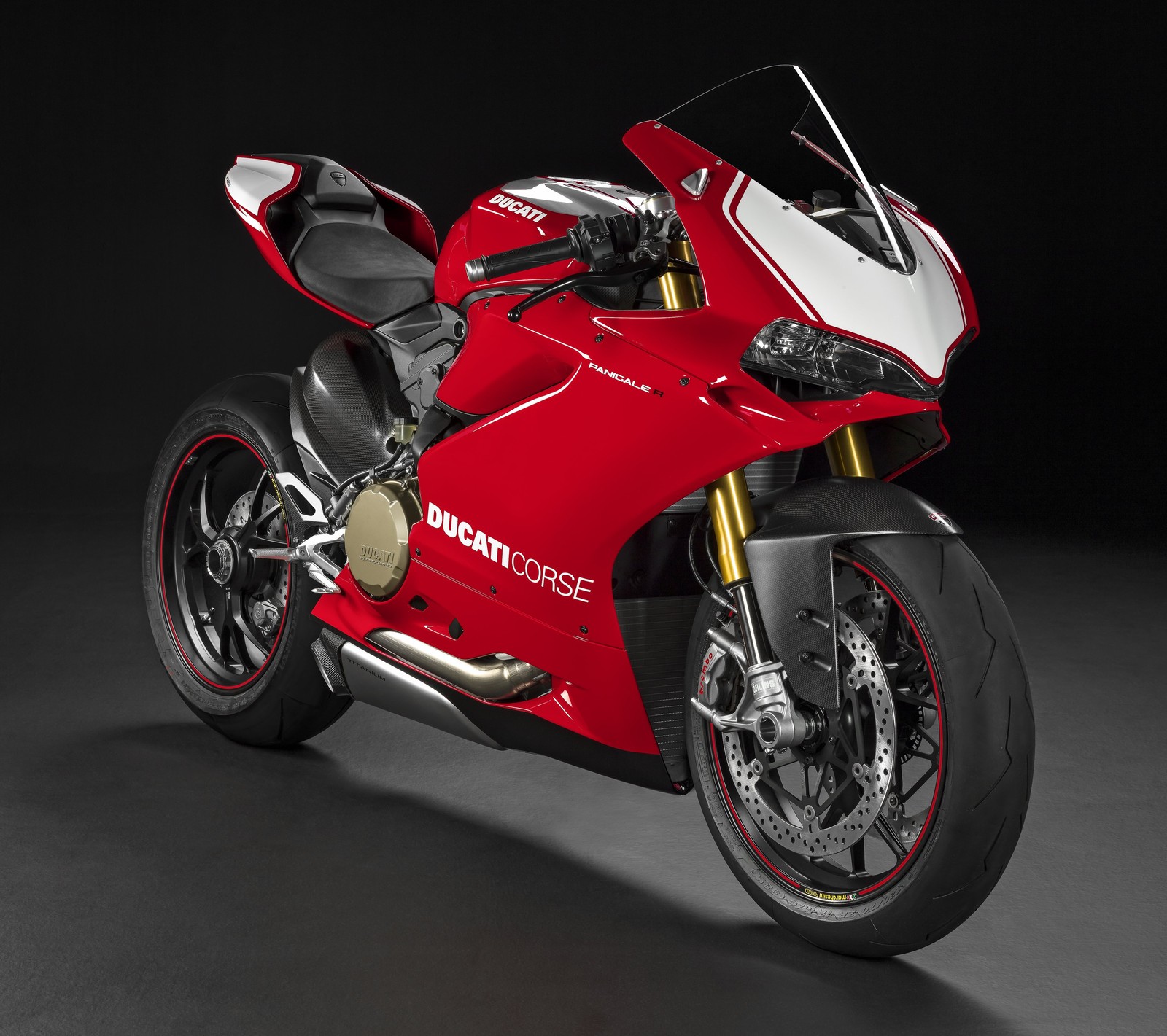 A close up of a red motorcycle parked in a dark room (ducati, italy, motorbike, superbike)