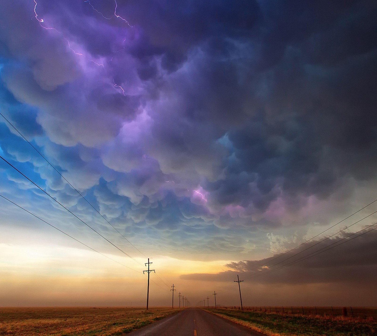 Un gros plan d'une route avec un ciel rempli d'éclairs (nuages, tempête, texas)