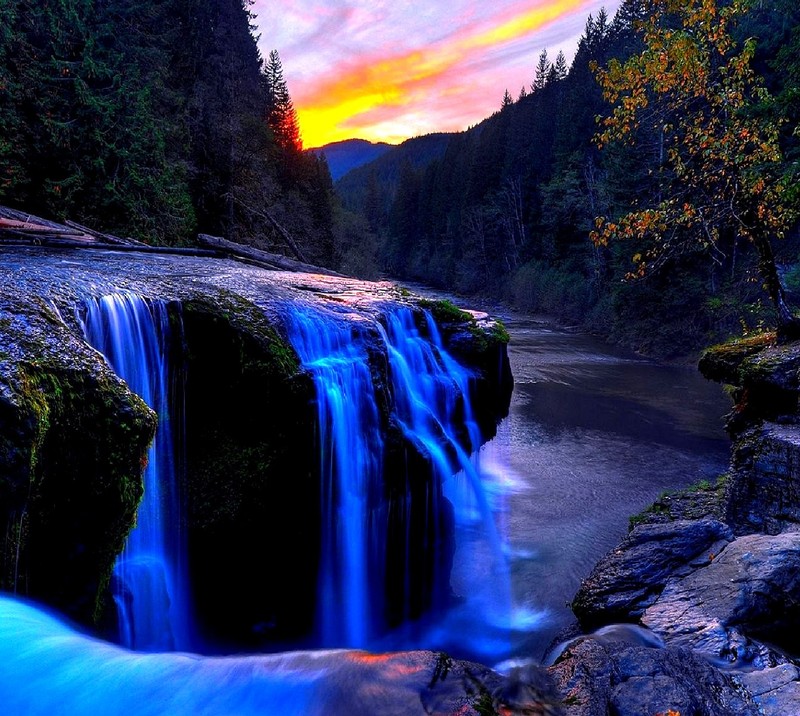 A close up of a waterfall with a sunset in the background (nature)