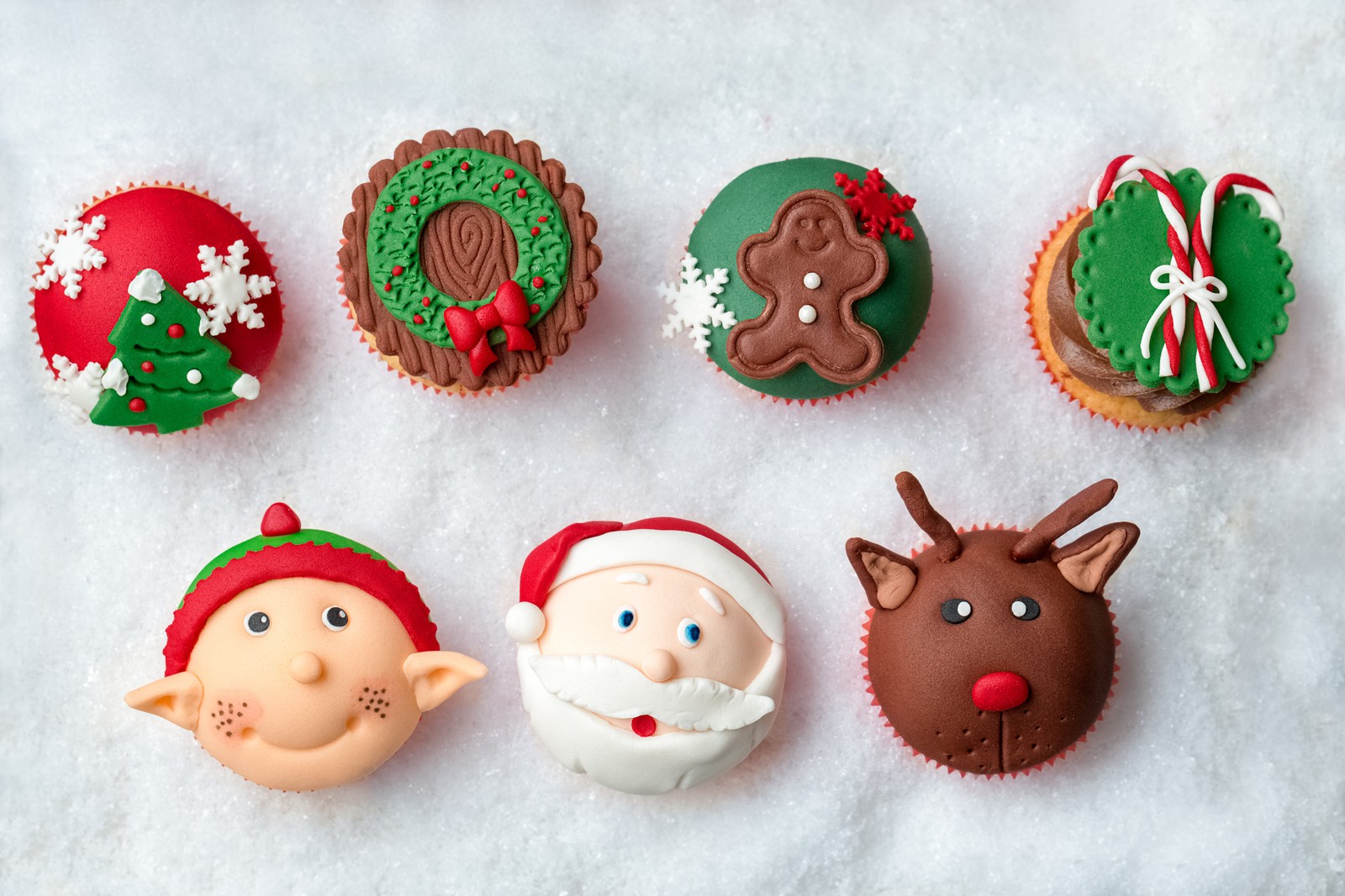 Hay muchos cupcakes decorados como santa claus y rudolph (nuevo año, navidad, pastelito, día de navidad, árbol de navidad)