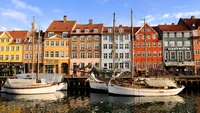 Charmant port avec des bâtiments colorés sur le front de mer et des voiliers reflétés