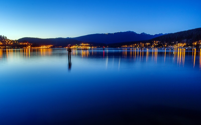 Вид на озеро с пирсом и горой на заднем плане (burrard inlet, фьорд, канада, британская колумбия, port moody)