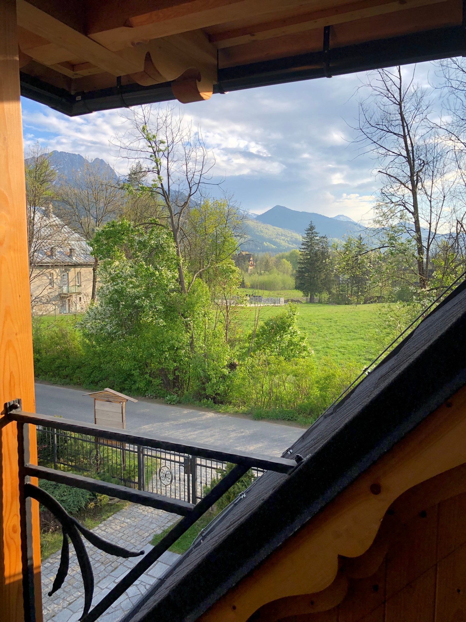 There is a view of a field from a balcony of a house (house, real estate, mountain range, shade, hill station)