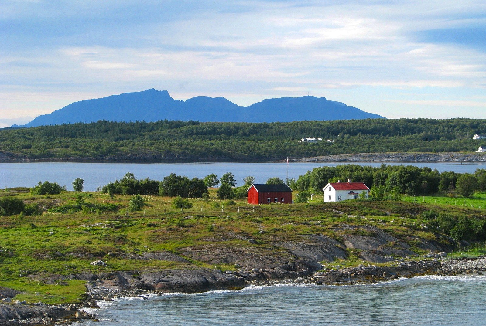 Il y a une petite maison rouge sur une petite île près de l'eau (loch, fjord, la côte, baie, entrée)