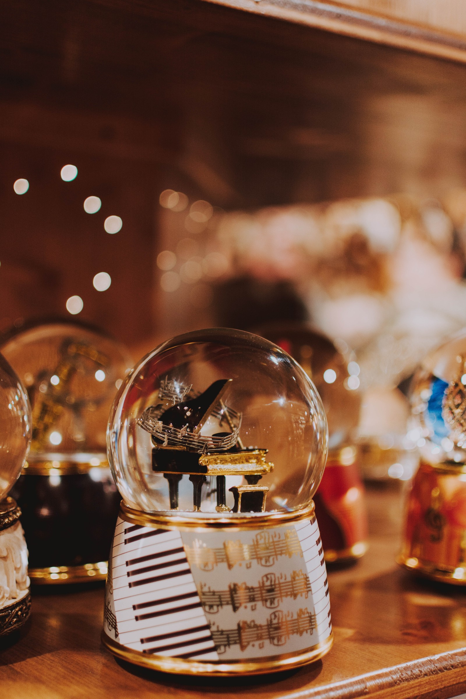 There are many snow globes on a table with a mirror (apple, ringtone, games, glass, liqueur)