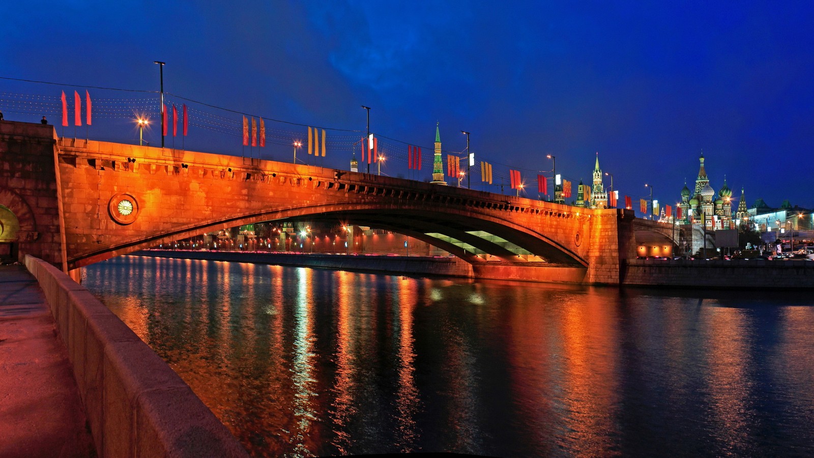 Blick auf eine brücke über einen fluss mit einem uhrturm im hintergrund (moskva fluss, nacht, wahrzeichen, brücke, reflexion)