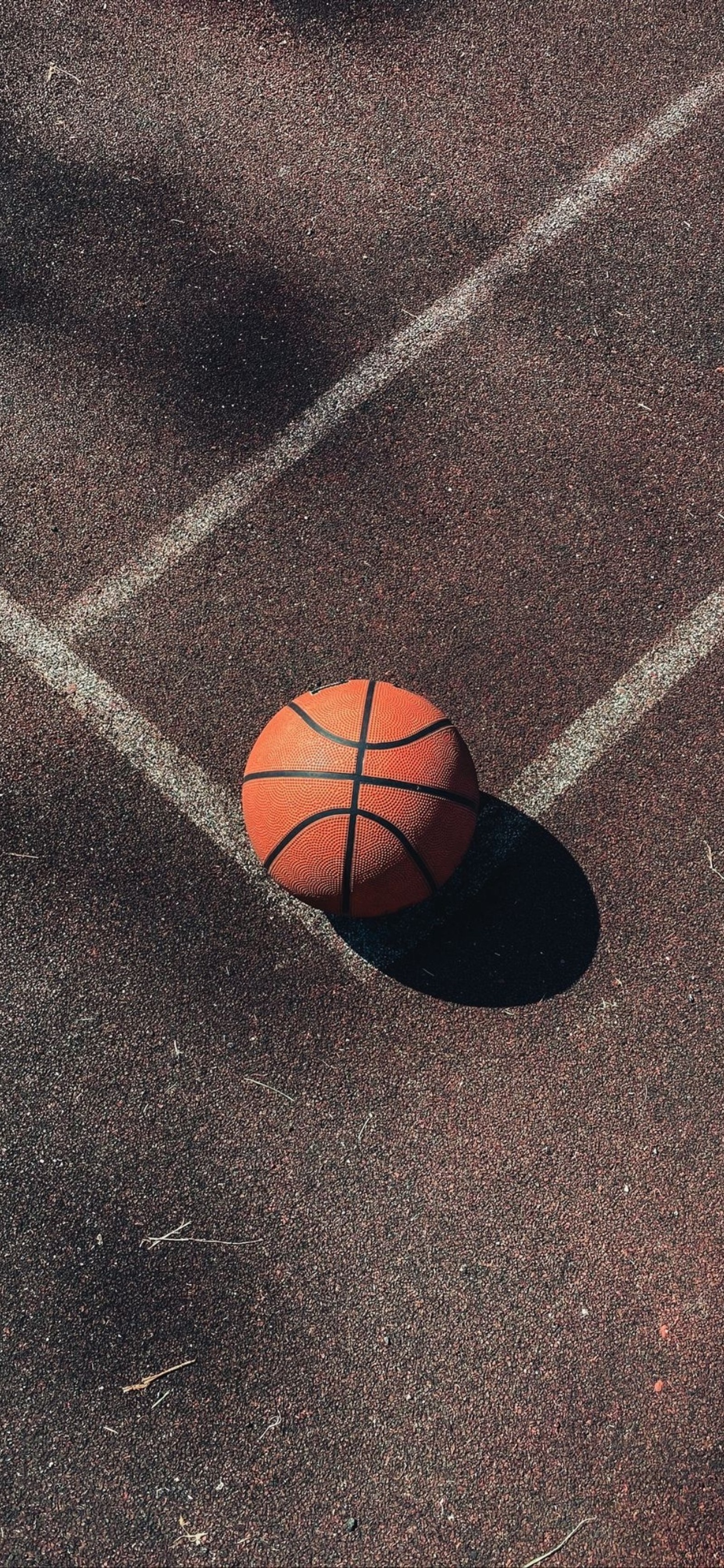 Arafed basketball ball on a court with a shadow on the ground (basketball, xiaomi, smartphone, sports equipment, ball)