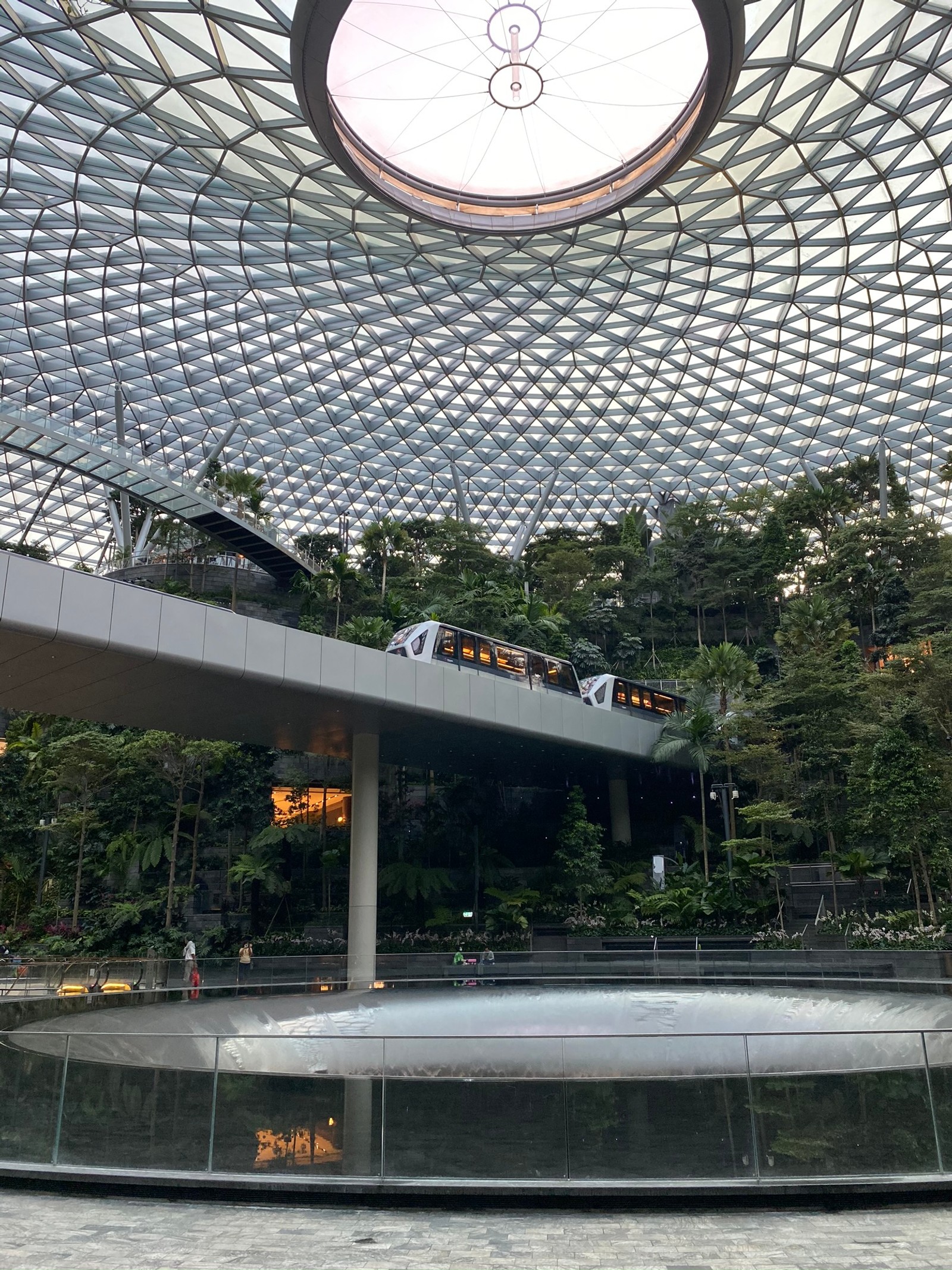 Há um trem passando por um domo de vidro (singapura, marco, iluminação natural, elemento de água, cúpula)