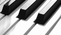 Close-up of a grand piano's black and white keys, showcasing a sleek and modern design.