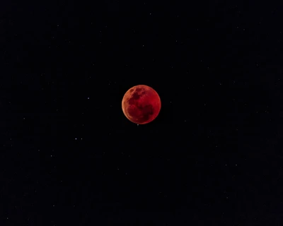 Vivid Red Full Moon During a Lunar Eclipse Against a Starry Night Sky