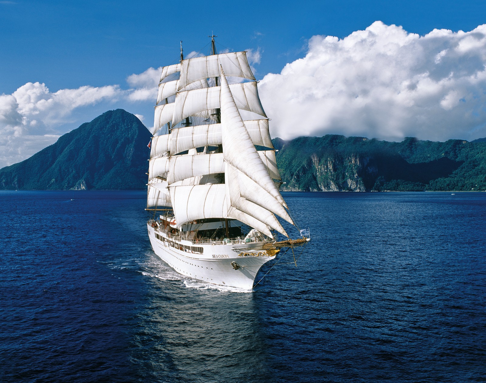 Velero árabe navegando en el océano con montañas de fondo (barco, barco de crucero, transporte acuático, barquentín, barco grande)