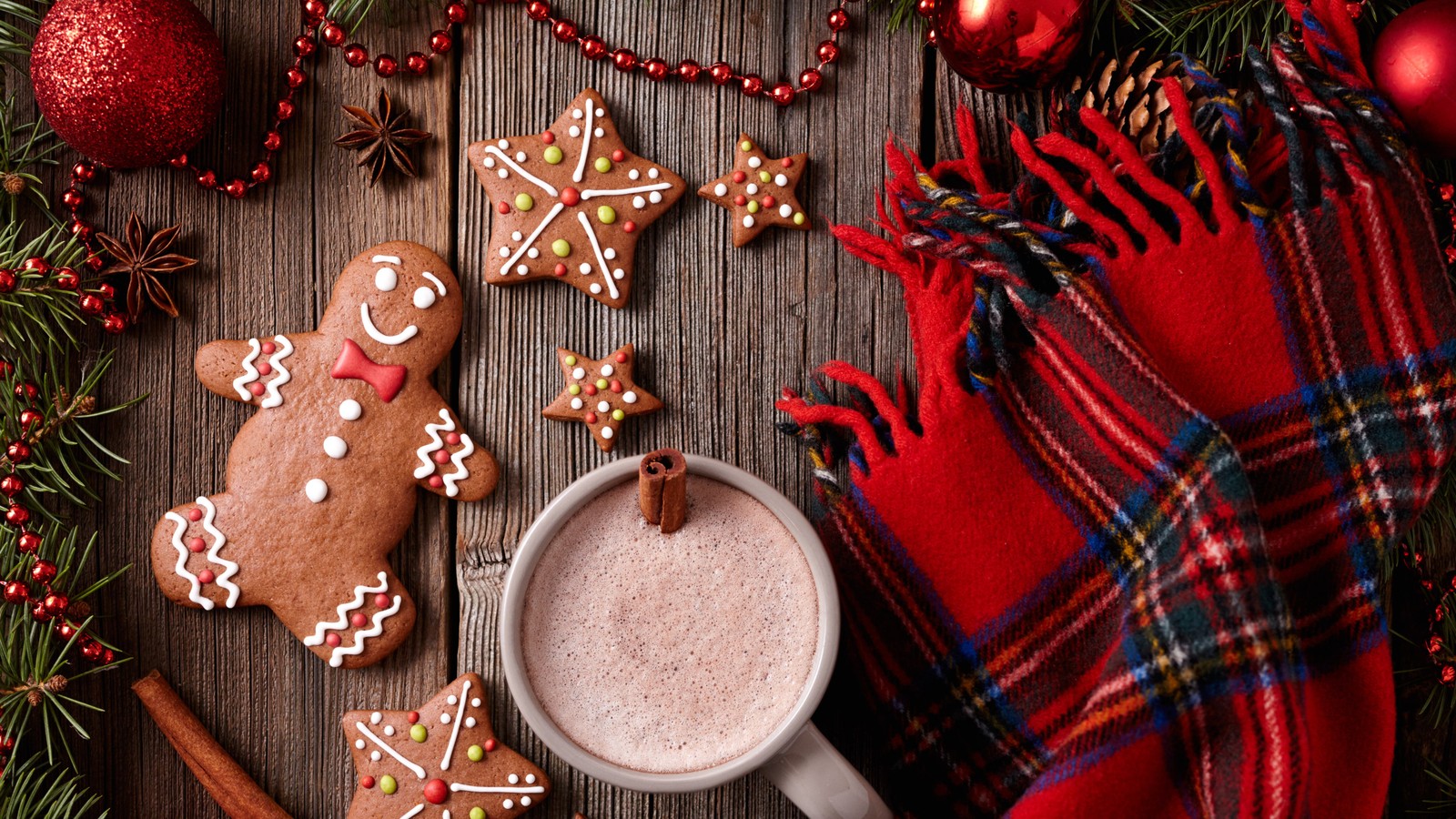 Un gros plan d'une tasse de chocolat chaud avec une décoration en pain d'épice (chocolat chaud, maison en pain dépice, homme en pain dépice, noël, cookie de noël)