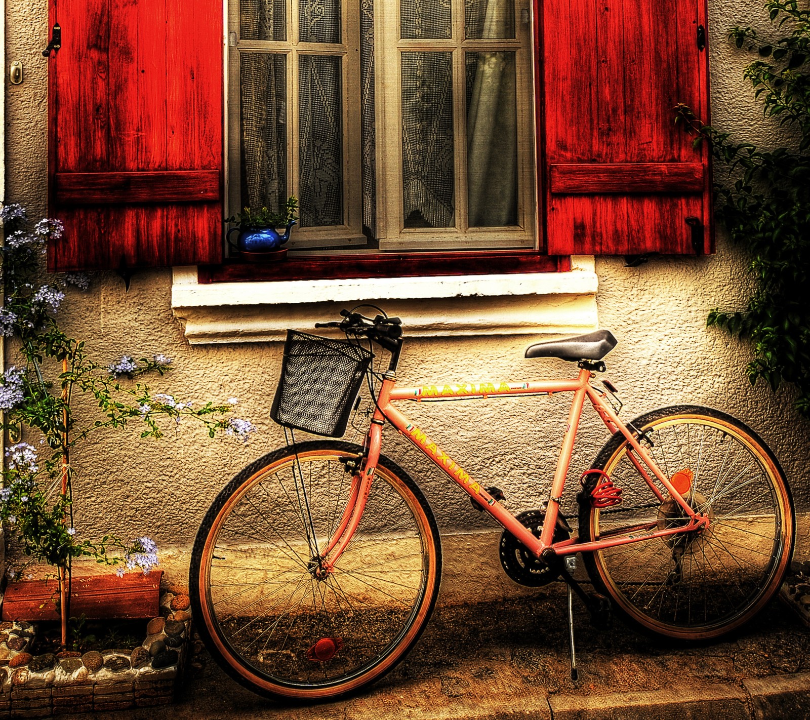 Ein verschwommenes fahrrad, das vor einem fenster mit roten fensterläden geparkt ist. (fahrrad, haus, romantik, romantisch)