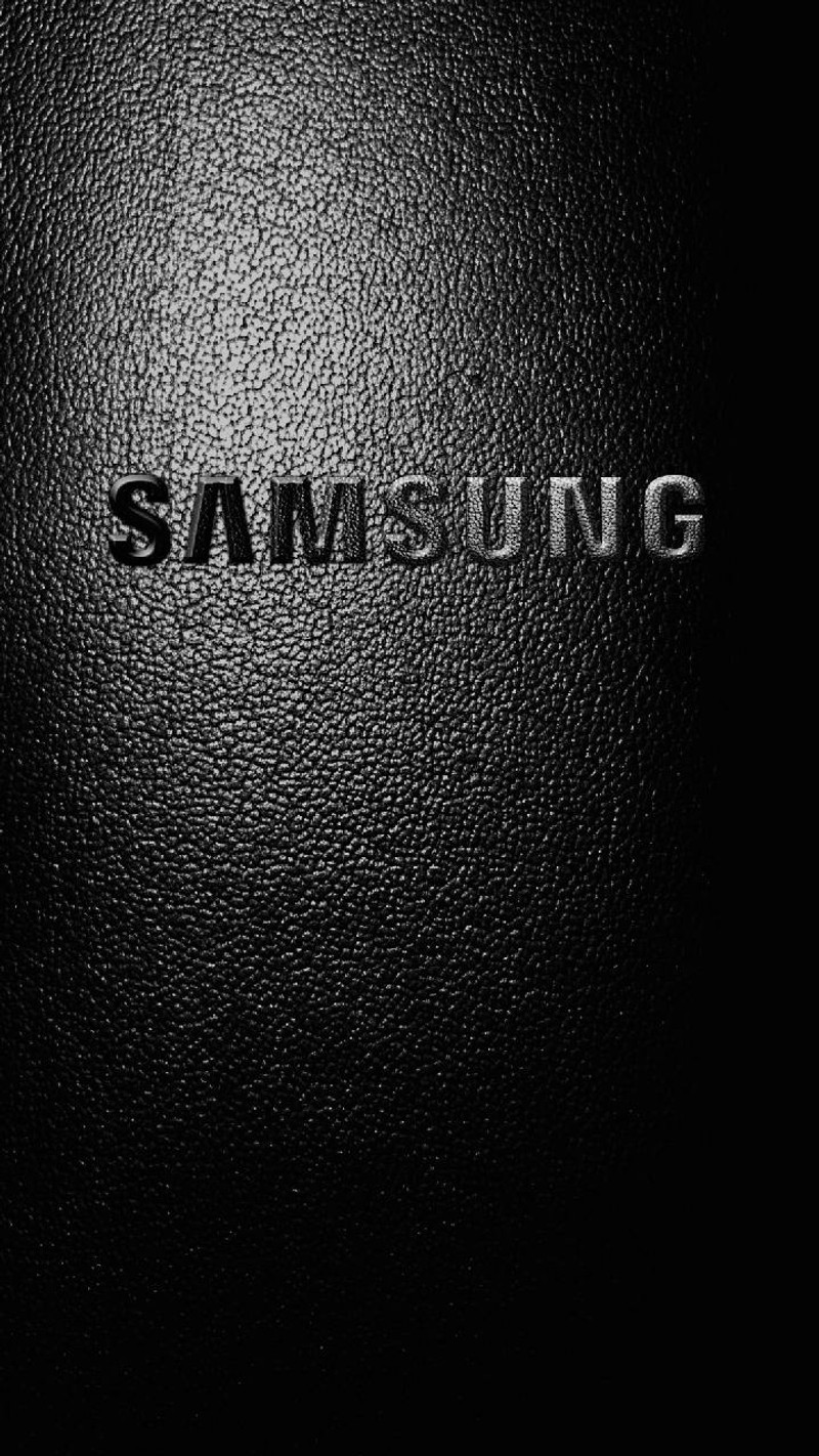 Близкий план черного логотипа samsung на черной поверхности (галактика, кожа, заметка)