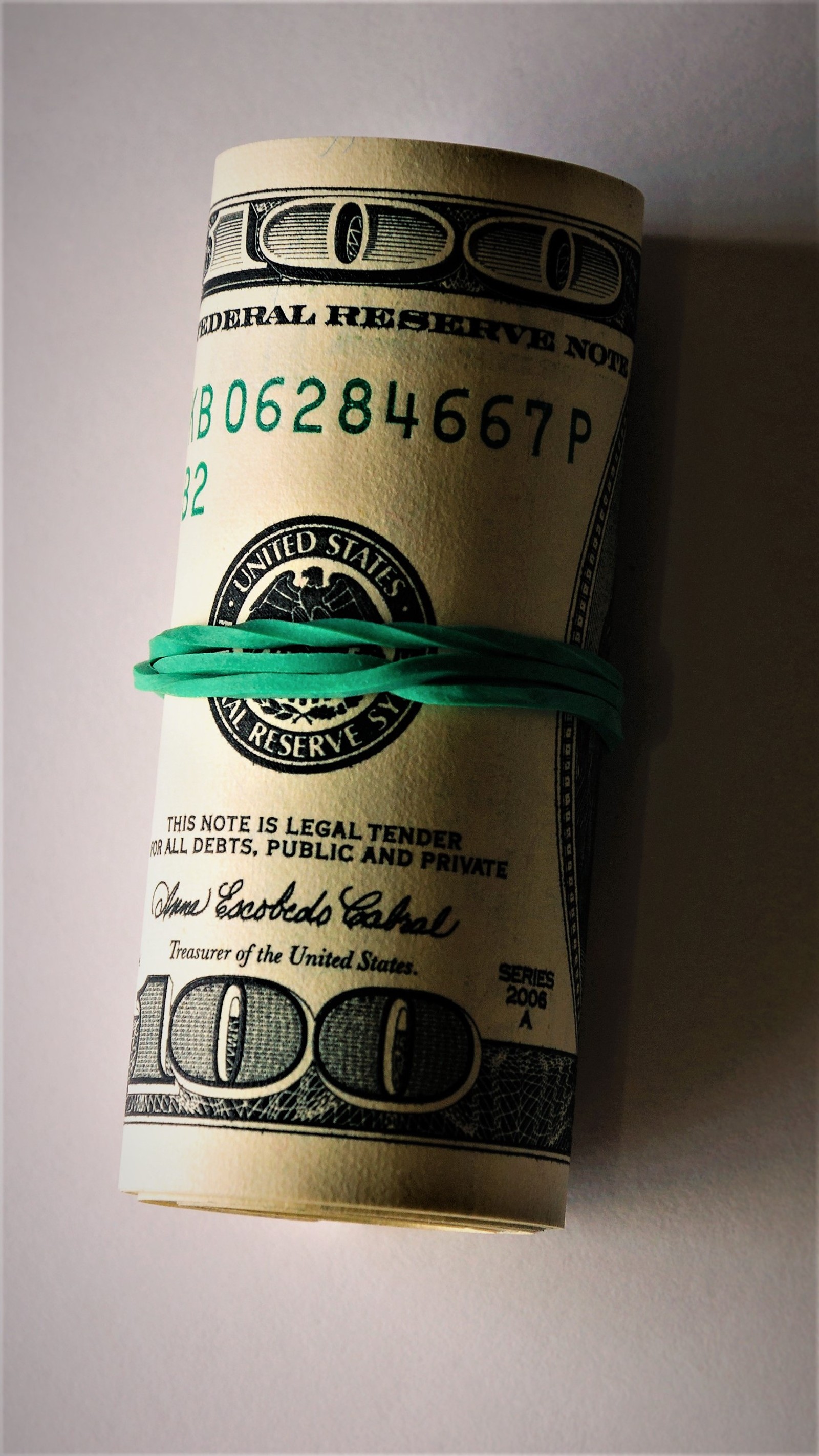 A close up of a roll of money wrapped in green string (abej, beograd, green, money)