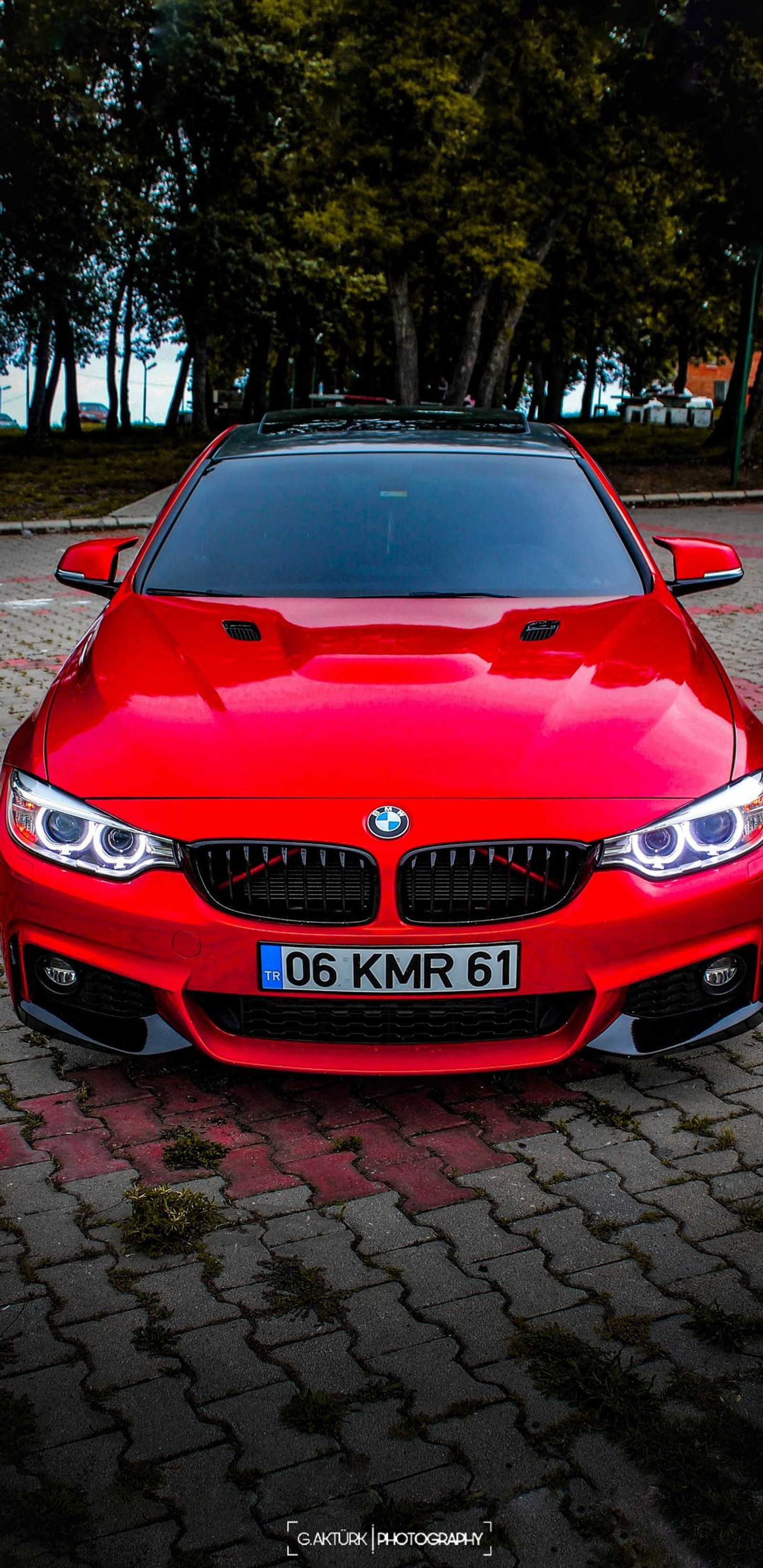 Um close em um carro bmw vermelho estacionado em uma estrada de tijolos (carro, bmw, vermelho)