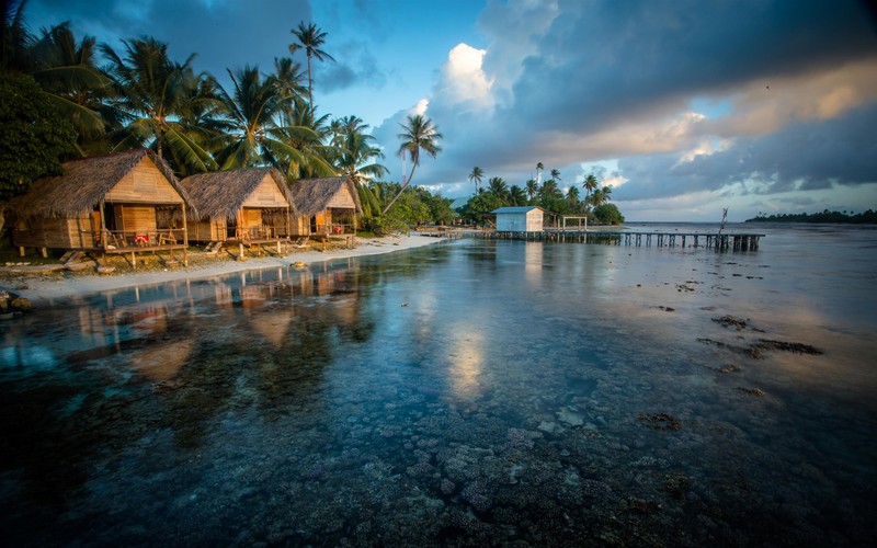 Eine aussicht auf einen strand mit einer hütte und einem pier (strand, kabine, feiertag, see, protokoll)