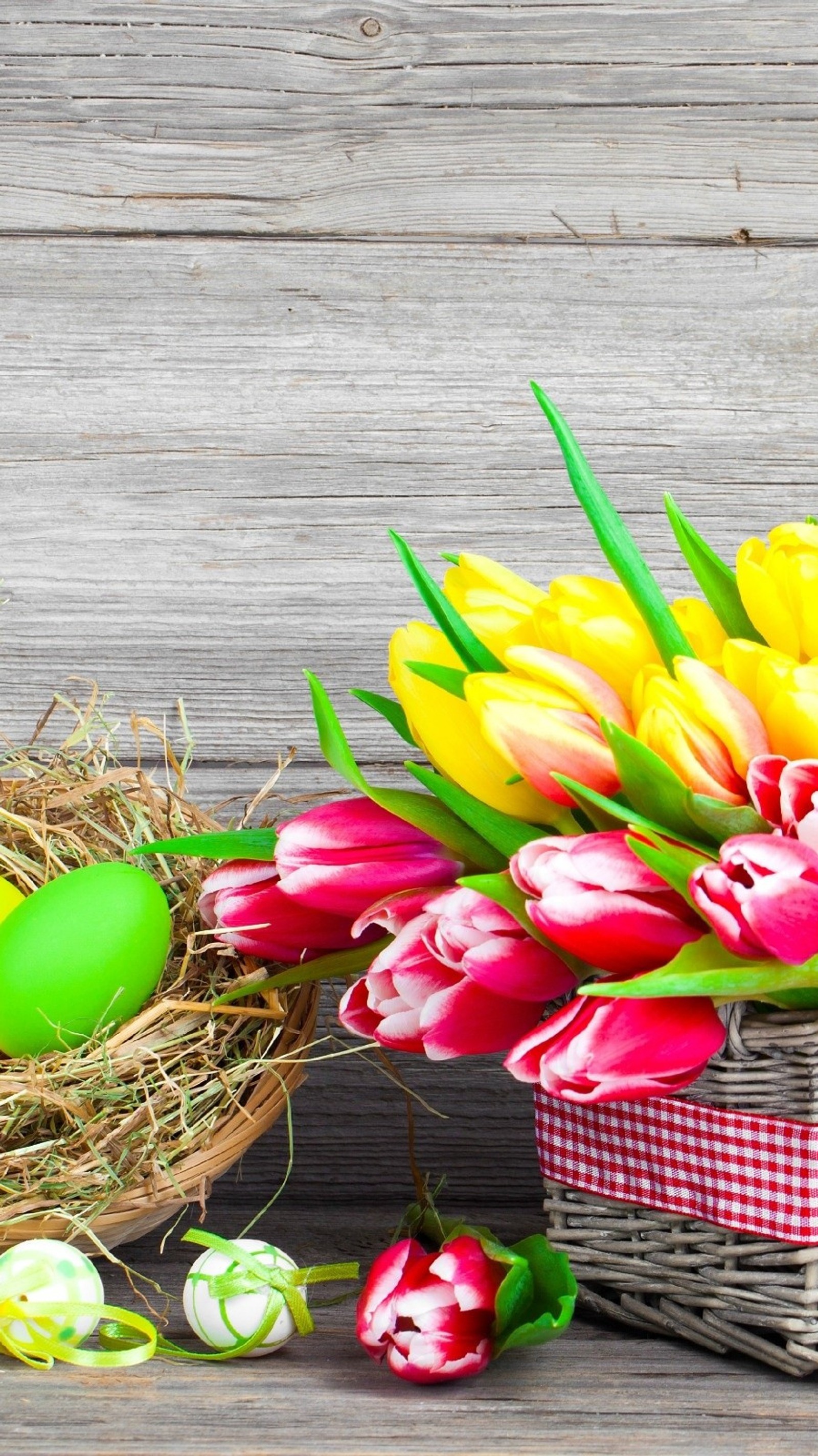 Il y a beaucoup de fleurs de différentes couleurs dans un panier sur la table (abstrait, couleur, pâques, œufs, fleurs)