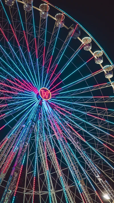 Rueda de la fortuna azul eléctrico iluminada a medianoche