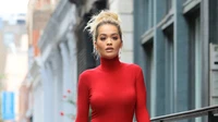 Rita Ora em um traje vermelho marcante que exibe a moda de rua trendy com um penteado elegante e lábios ousados.