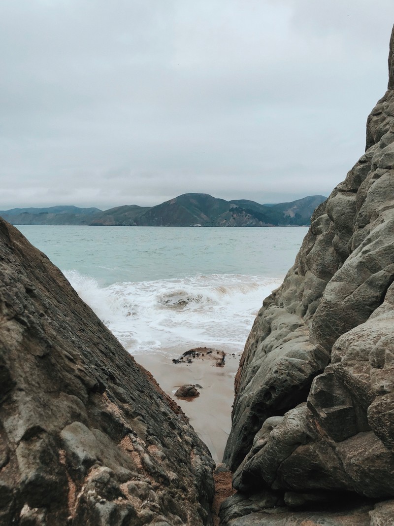 Взгляд на пляж с камнями и водой (море, вода, мыс, скала, берег)