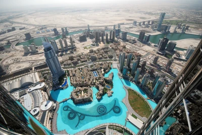 Aerial view of the Burj Khalifa observation deck overlooking Dubai's urban landscape, featuring a vibrant cityscape, intricate waterways, and the iconic skyscraper amidst a sprawling metropolis.