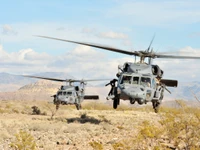 Sikorsky UH-60 Black Hawk Hubschrauber im Flug über eine Wüstenlandschaft.