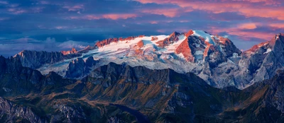 Marmolada Glacier at Sunset: A breathtaking aerial view of snow-covered peaks in Italy's mountain range, showcasing nature's beauty and vibrant colors.