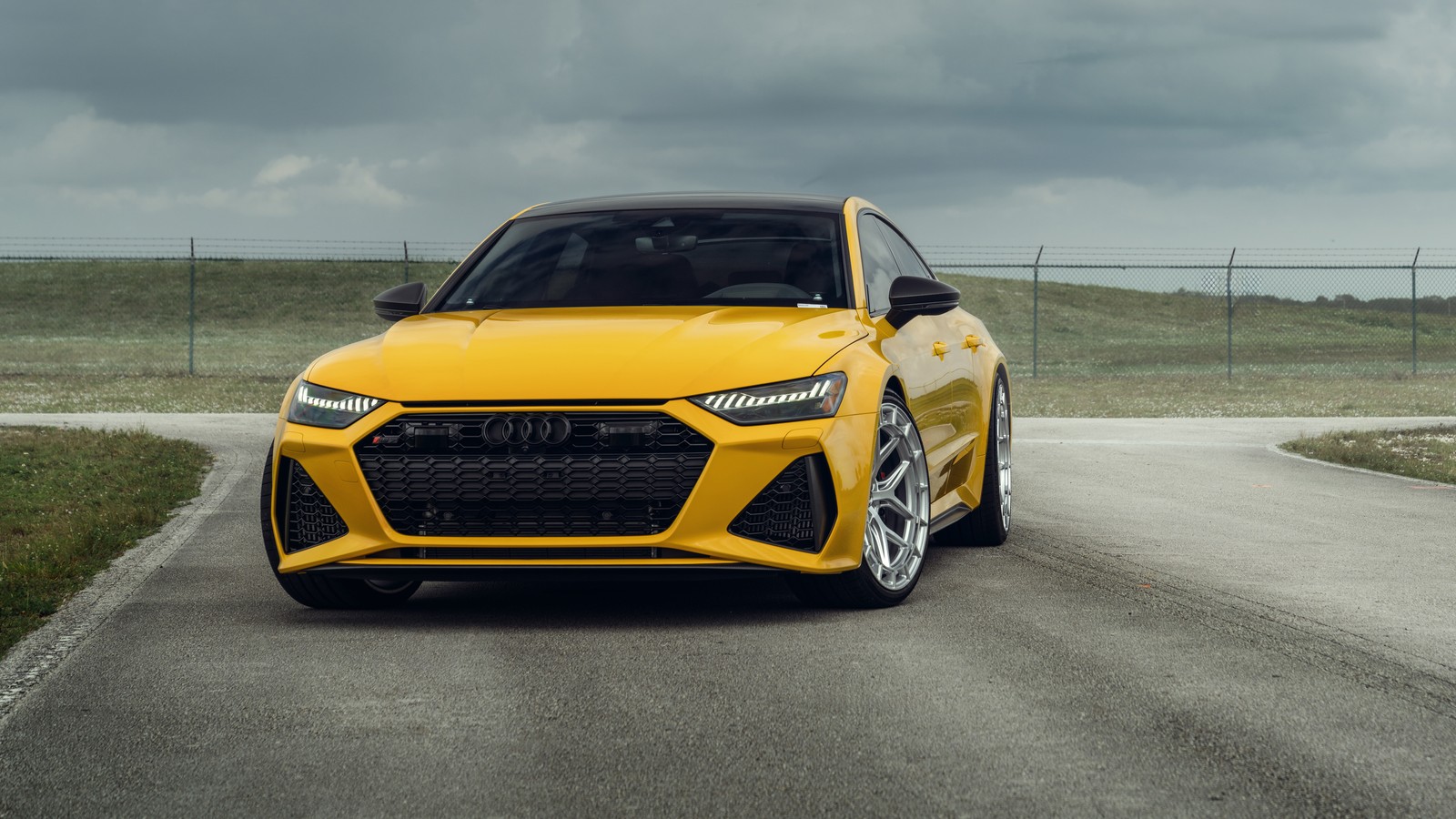 Un audi rs3 amarillo conduciendo por una carretera con un cielo nublado (audi rs 7 sportback, 8k, 5k, coches, fondo de pantalla 4k)